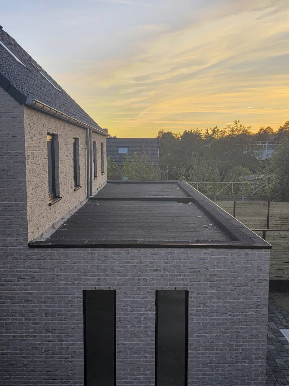 Plat dak met bitumineuze afwerking, op een aangeleverde werffoto van STX Roofing.